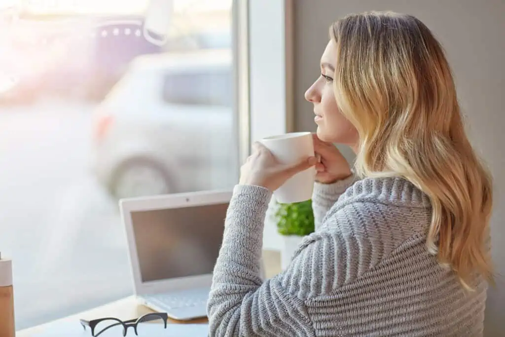 A woman holding a mug contemplating consultation fees